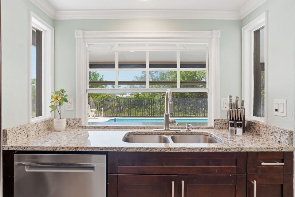 Bright kitchen with granite counters and pool-view window