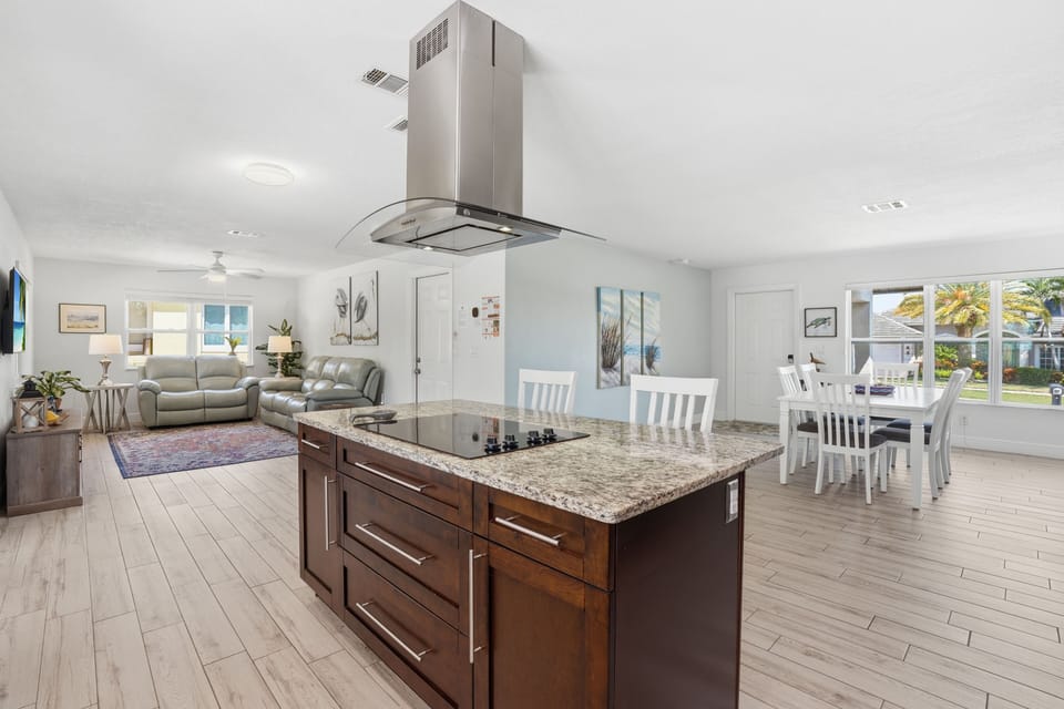 Bright open-concept kitchen, dining, and living space with stylish island