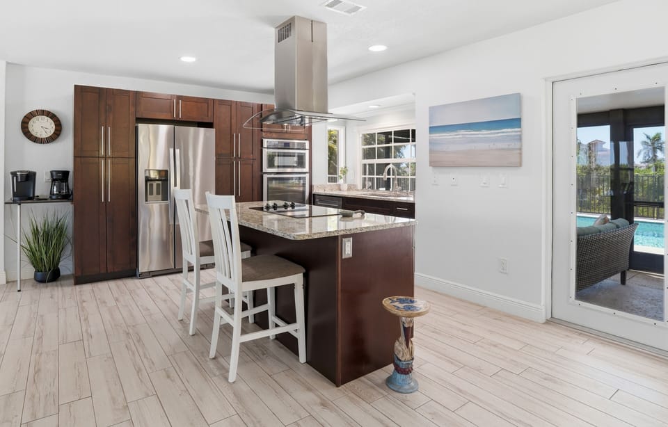 Bright modern kitchen with granite island and easy poolside access