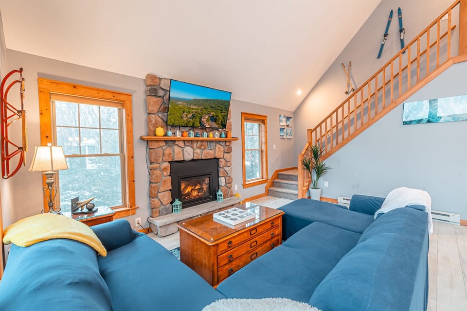 Cozy up by the stone fireplace after a day on the slopes—surrounded by rustic charm, soft throws, and mountain warmth.
