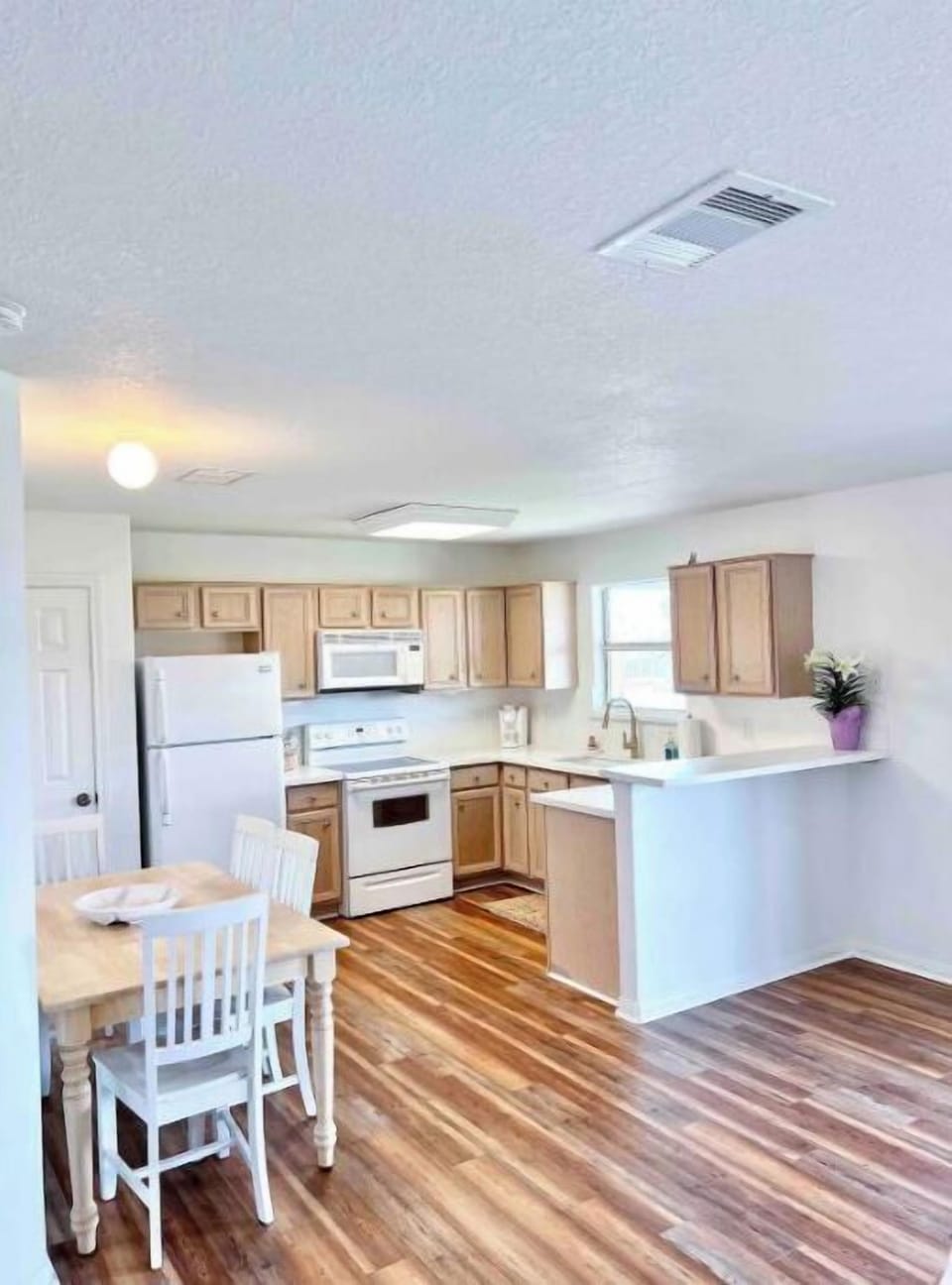 Dining area seats four plus two barstool at countertop.