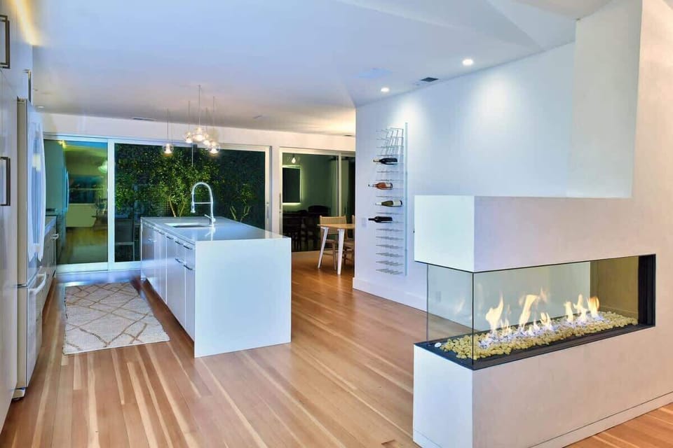 Modern open-concept kitchen and living area with cozy fireplace