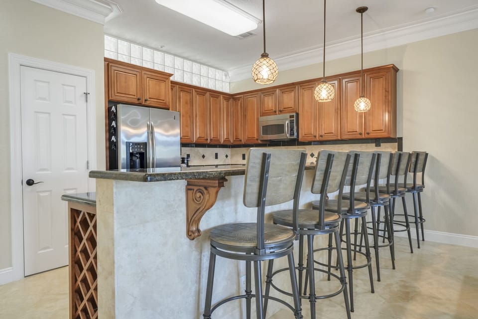Bar Area, 6 Chairs, with Kitchen in Background.