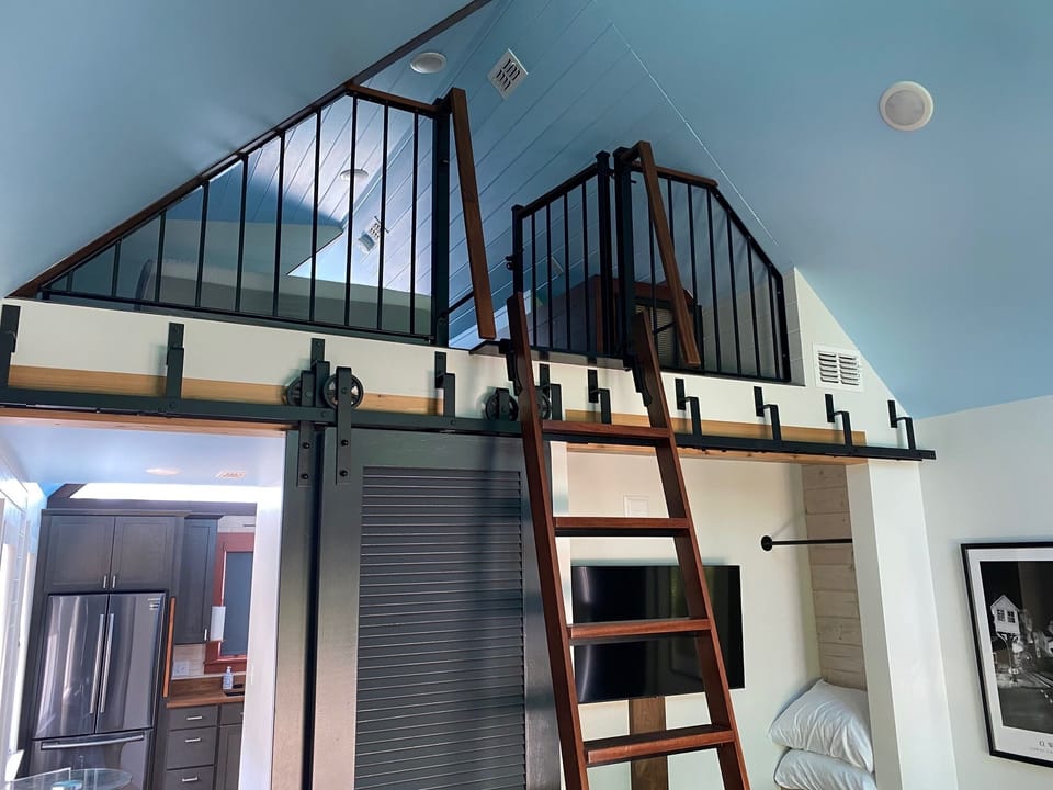 Loft & living room with view to kitchen's stainless steel fridge 