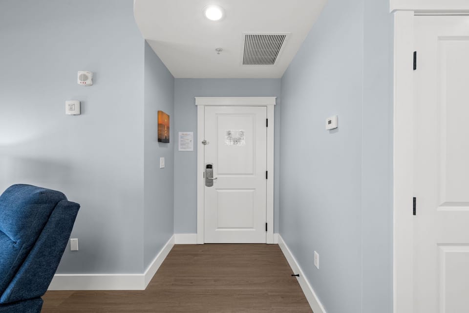 Your private entryway welcomes you with calming blue walls and warm hardwood floors, creating a peaceful transition into your home away from home.