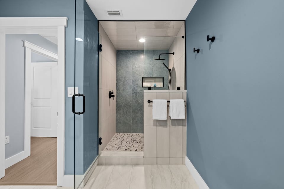 Step into your modern spa-like bathroom where sleek stone and glass create a luxurious retreat for unwinding.