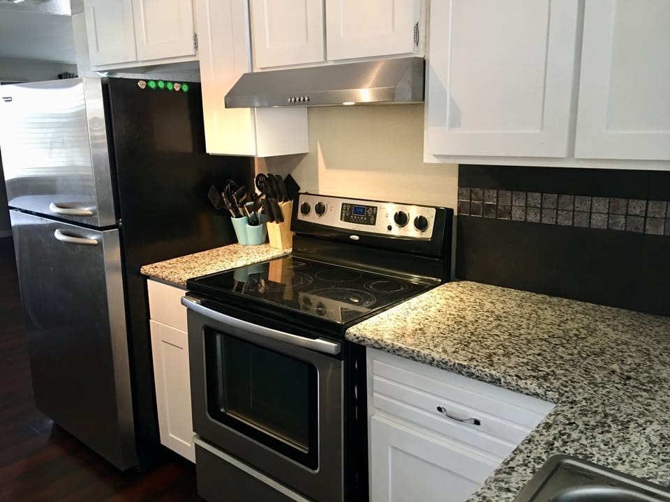 The kitchen is stocked with dishes, utensils and pots and pans.