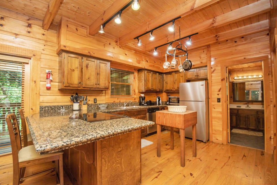 Granite countertops with 2 bar stools add extra seating next to dining table.