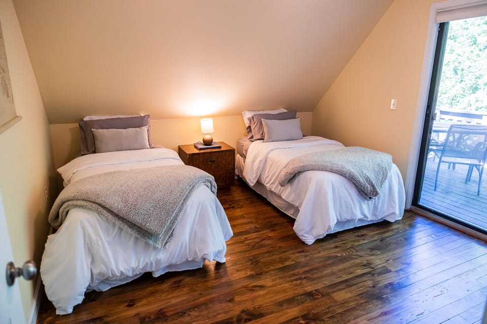 Second floor bedroom with twin beds. and uncovered patio area access