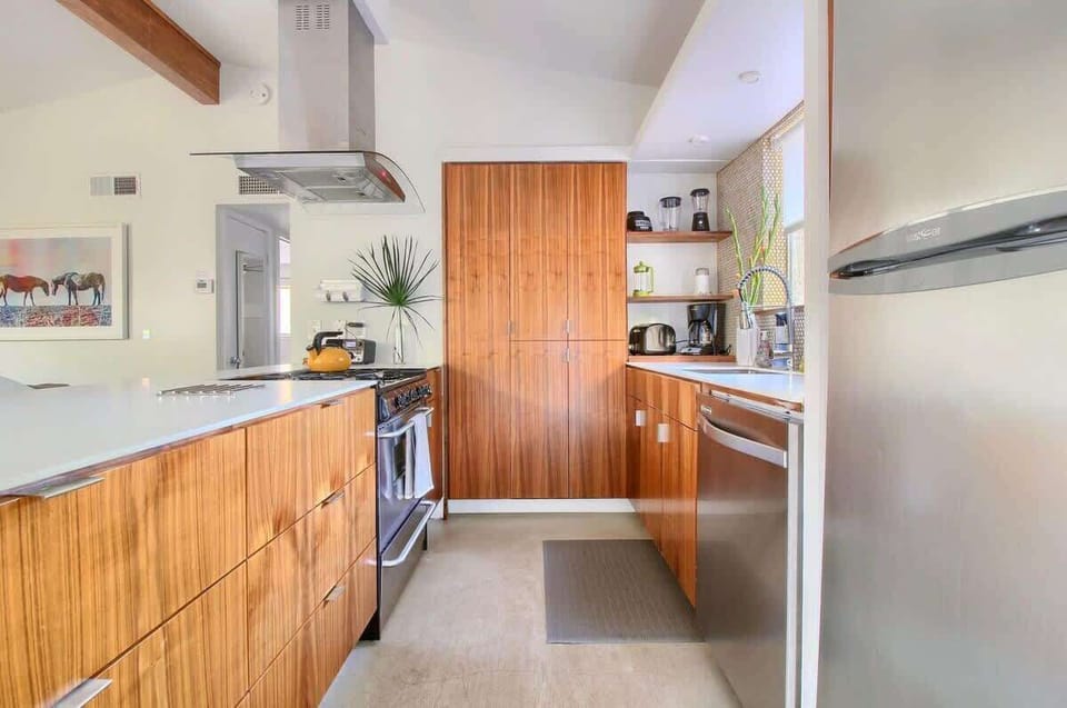 Kitchen with Stainless Appliances, Dishes, and Cookware.