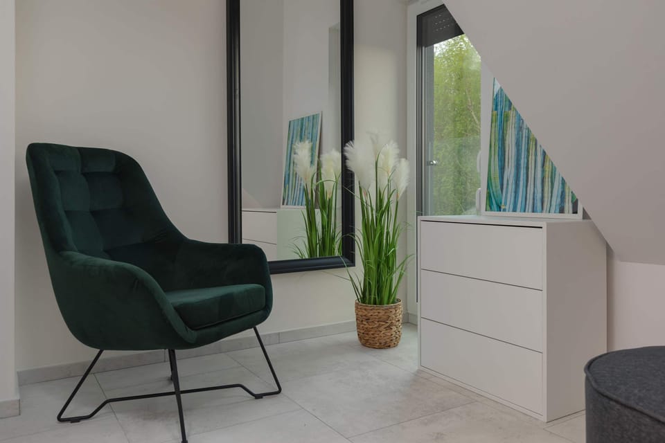 Armchair, chest of drawers and mirror in the bedroom.