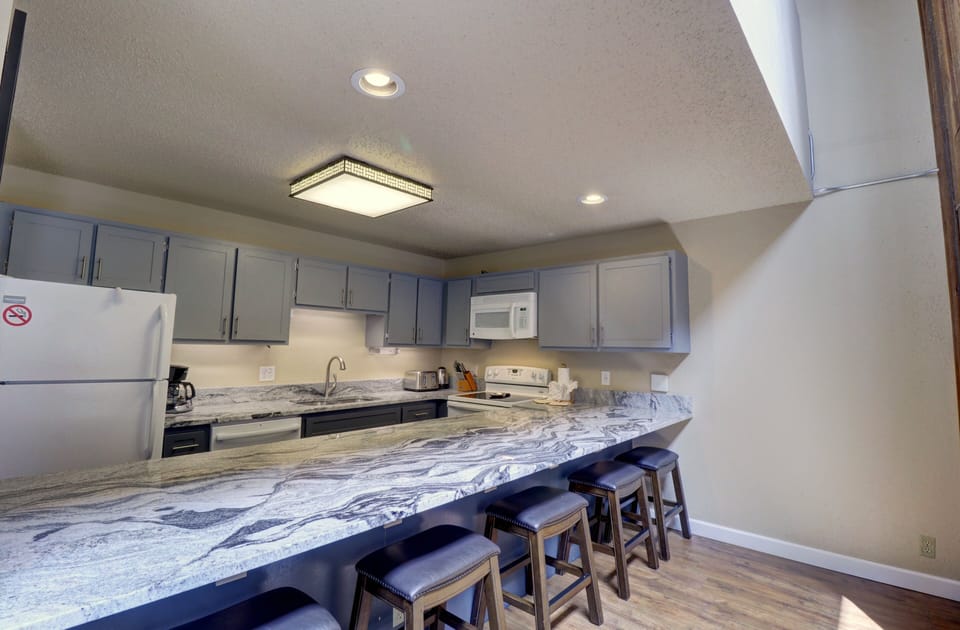 Kitchen area with bar stool seating at counter.