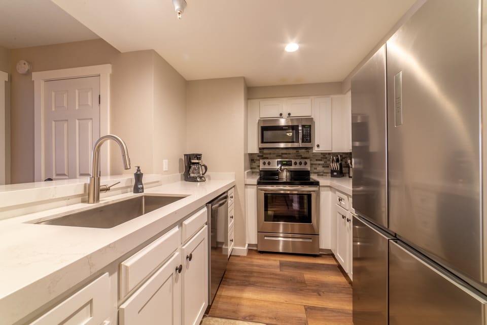 Remodeled kitchen w/ large under mount sink, stainless steel appliances and quartz countertops.