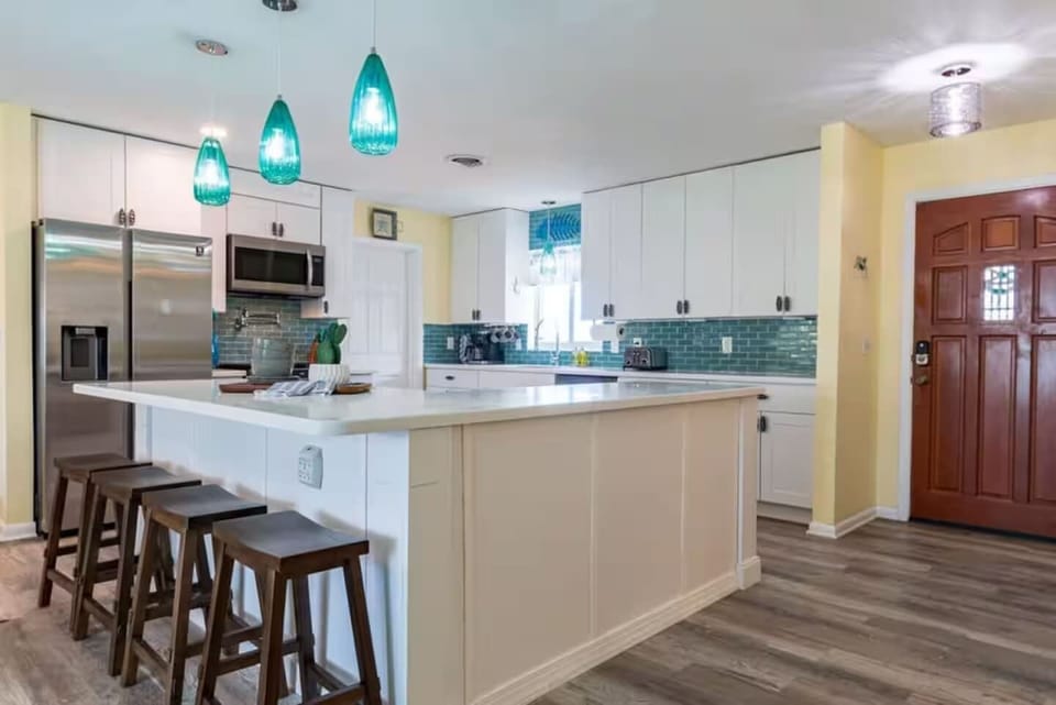 Modern kitchen with a large island and teal pendant lighting