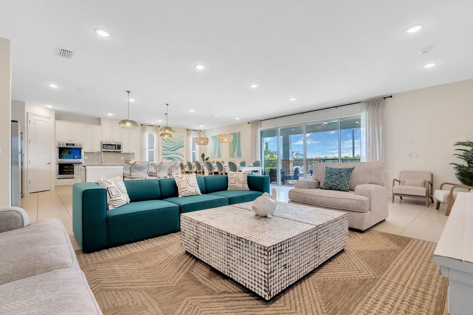 - Spacious open living room with modern seating for groups  
- Bright design with sliding doors leading to outdoor patio  
- Perfect central space for gathering and family relaxation