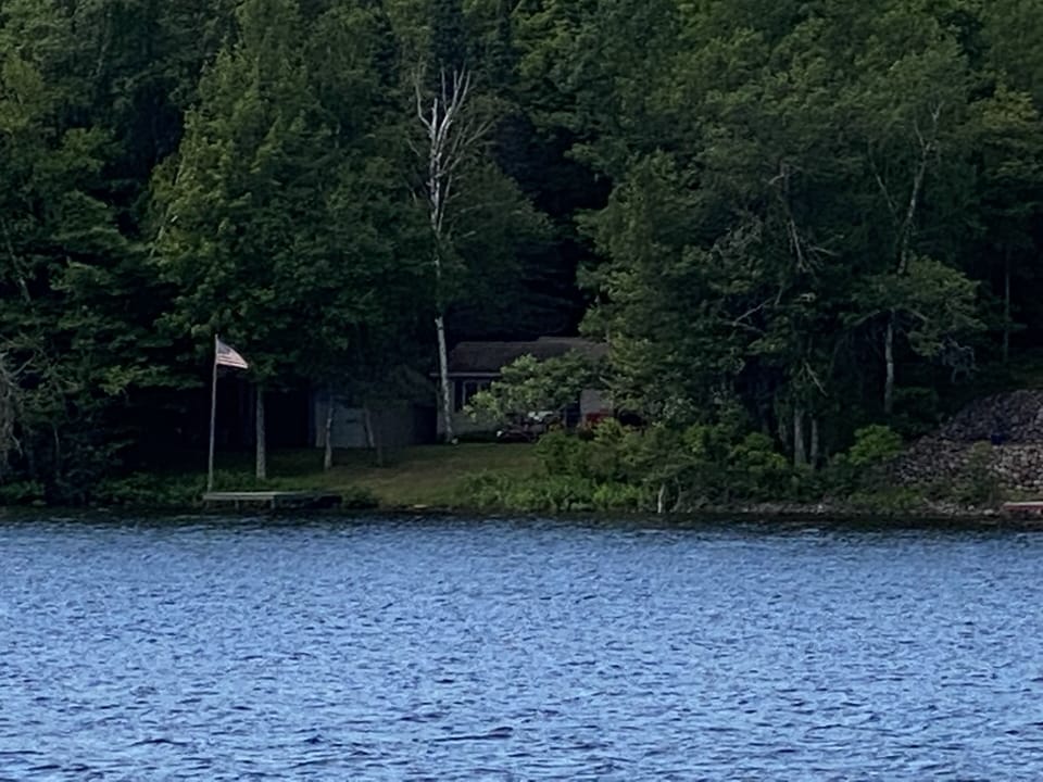 Property view from water. Flagpole on dock.