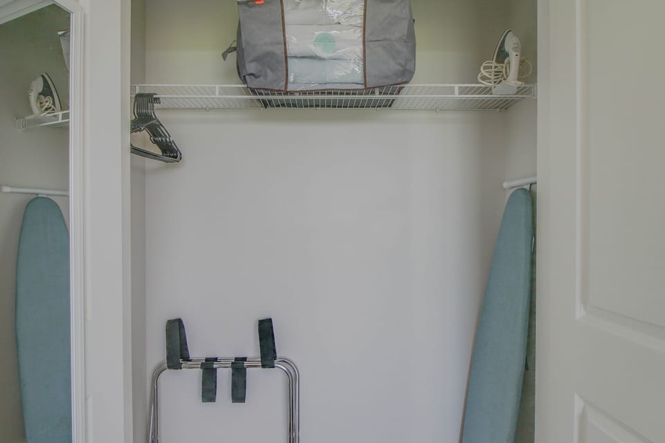 Spacious closet stocked with hangers + iron/ ironing board + luggage rack!
