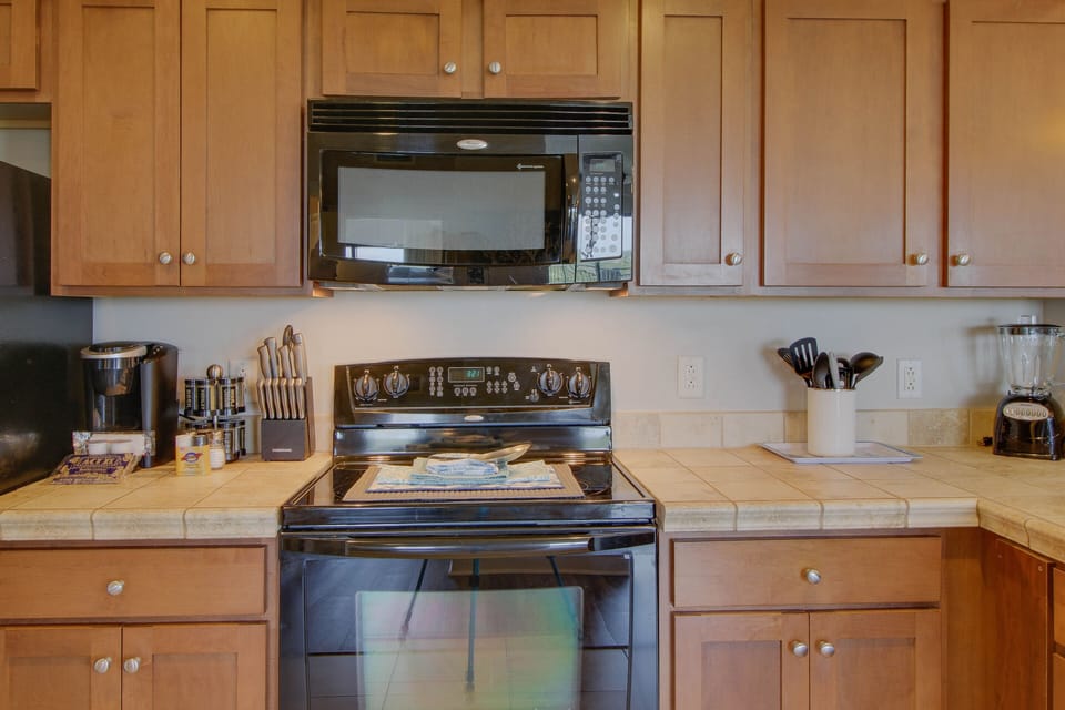 This kitchen comes stocked with a single serve coffee machine + blender + microwave + stove!