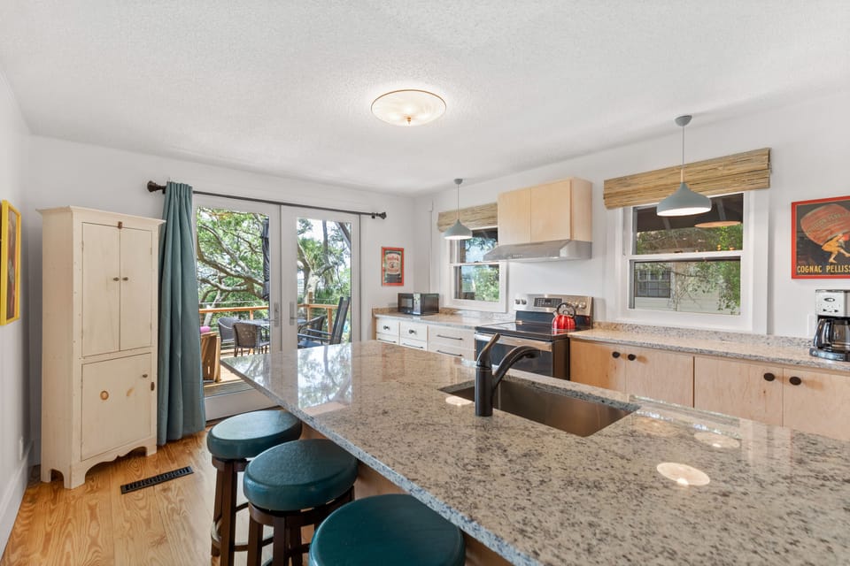 The kitchen in the home boasts a four person breakfast bar, updated appliances, and french doors leading to the spacious deck.