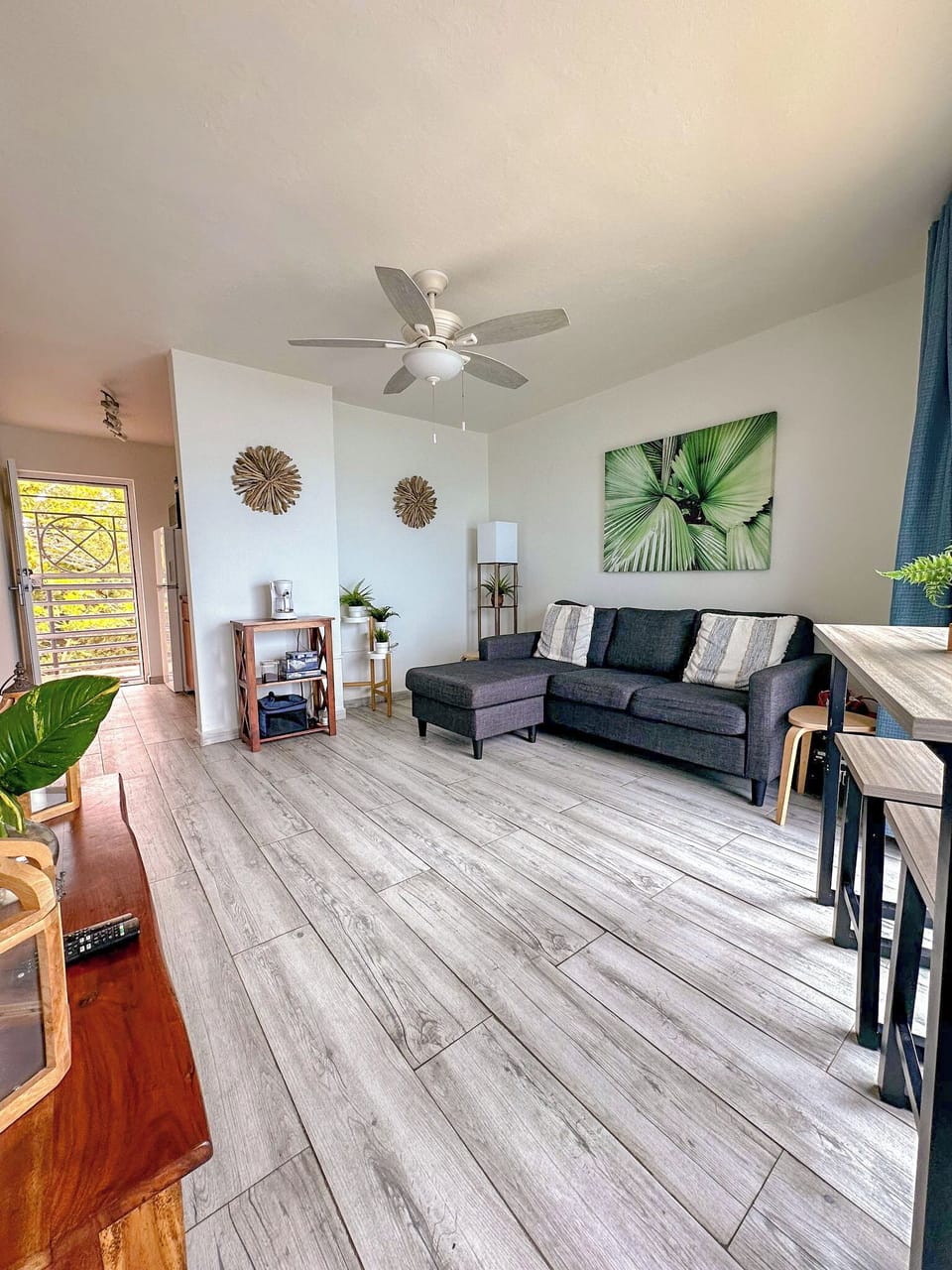 Living Room Oasis: Bright space with tropical decor, perfect for relaxation and unwinding!