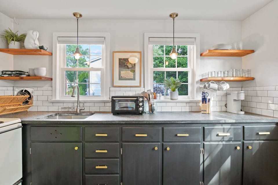 Spacious and bright, fully equipped kitchen is decorated with unique tiled floor