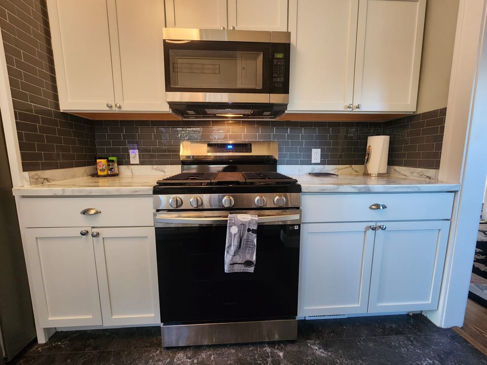 Self cleaning gas range with center griddle, microwave and counter space