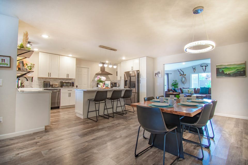 Spacious dining room and kitchen with a large center island and dining table.