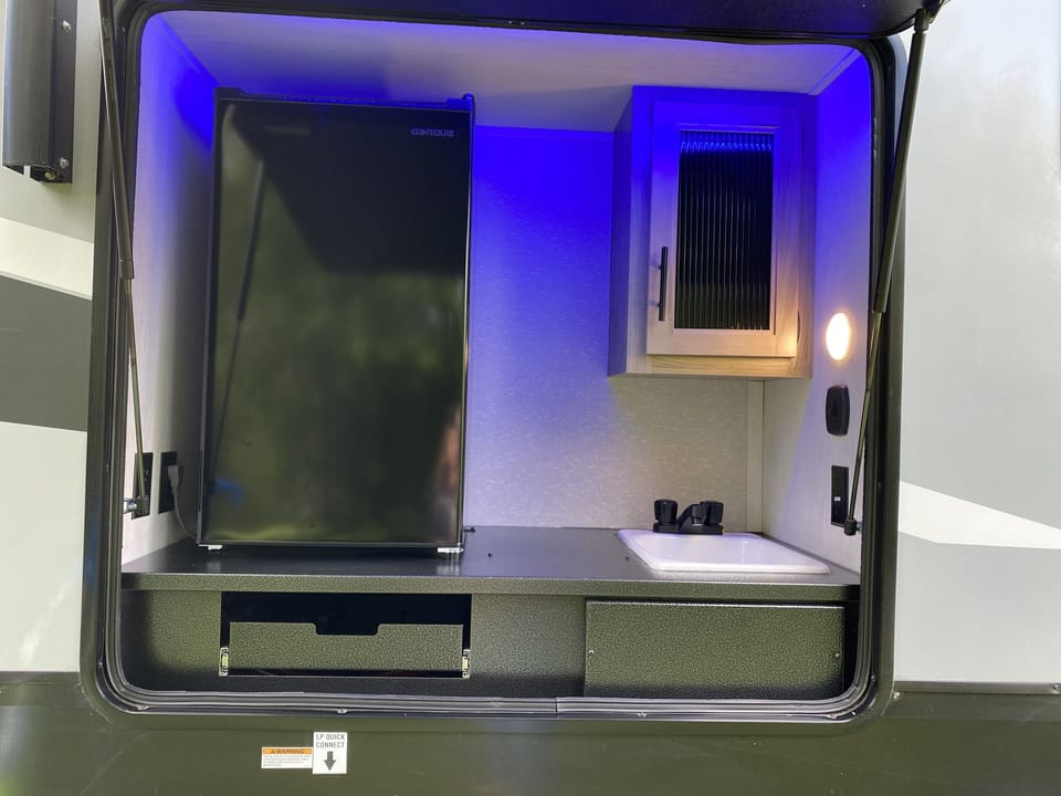 Outdoor kitchen with small refrigerator and sink