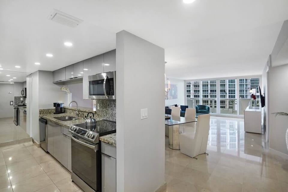 Fully equipped kitchen with washer/dryer, dining/living room, balcony access