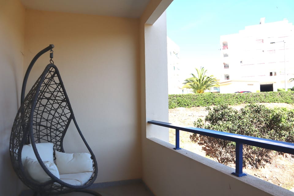 Varanda do quarto com cadeira suspensa.