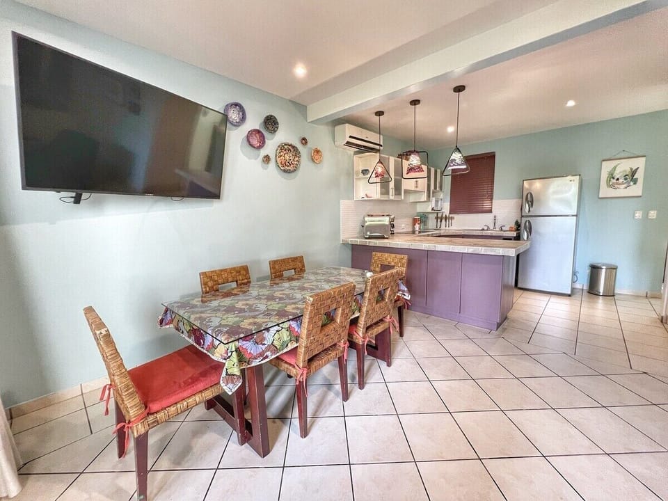 Open concept dining and kitchen with large-screen TV. 