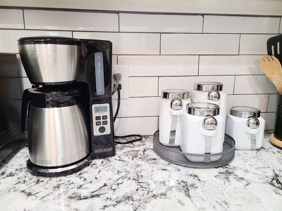 Drip coffee machine with coffee, and sweeteners.