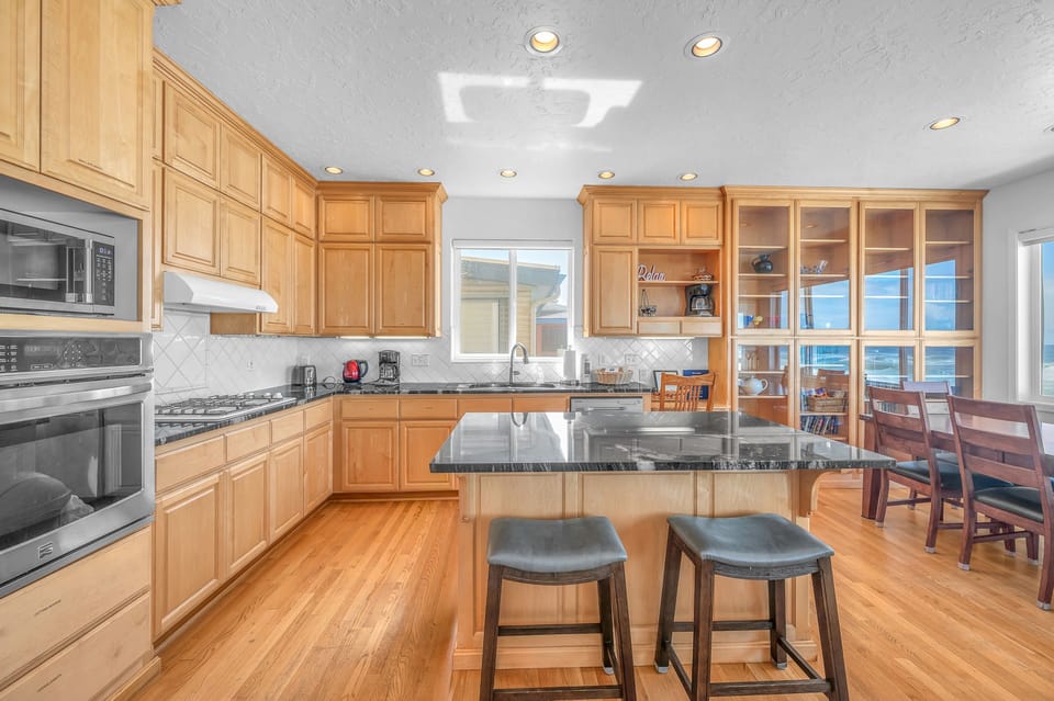 Your spacious kitchen features granite countertops, warm wood cabinets, and modern appliances, creating the perfect space for preparing meals together.