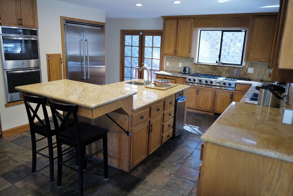Gourmet kitchen with double ovens, gas rangetop, spacious countertops, & island