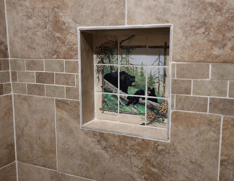 Shower with custom black bear tile accents