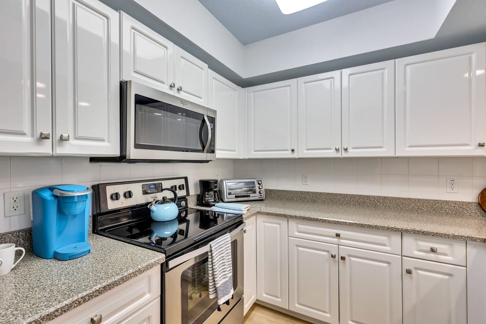 fully equipped kitchen with coffee maker, keurig, toaster oven, microwave, stove
