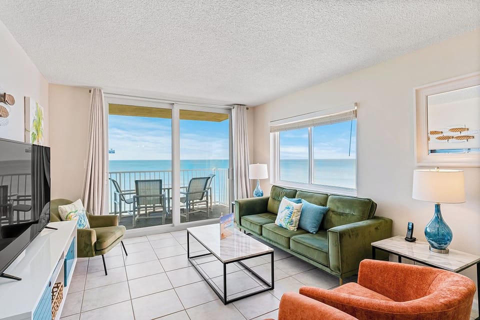 Unwind in your oceanfront living room where floor-to-ceiling windows frame endless sea views and your private balcony awaits.