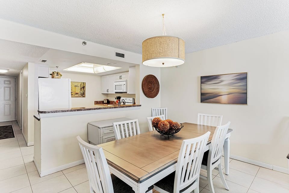 Your bright dining space flows seamlessly into the modern kitchen, perfect for memorable meals together under warm pendant lighting.