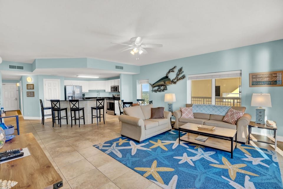 Unwind in your spacious coastal retreat with soothing blue walls, comfortable seating, and starfish-themed decor that brings ocean vibes inside.