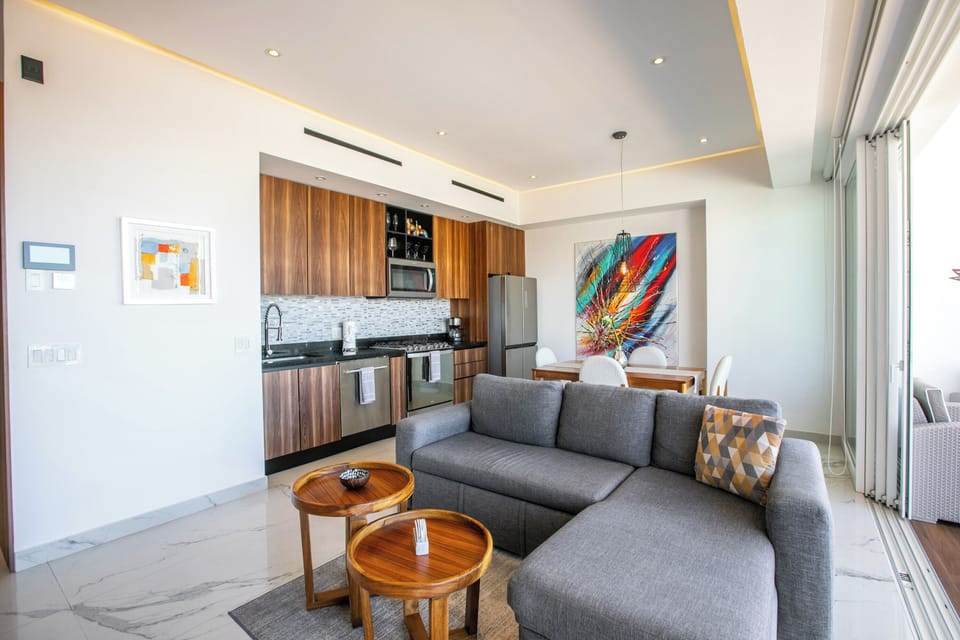 Unwind in your stylish open-plan living space with modern furnishings and vibrant artwork creating a welcoming atmosphere for relaxation.