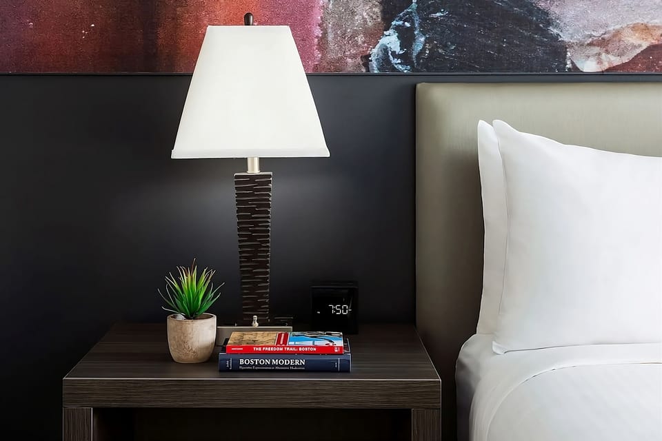 Unwind beside warm lighting with bedside essentials within reach.