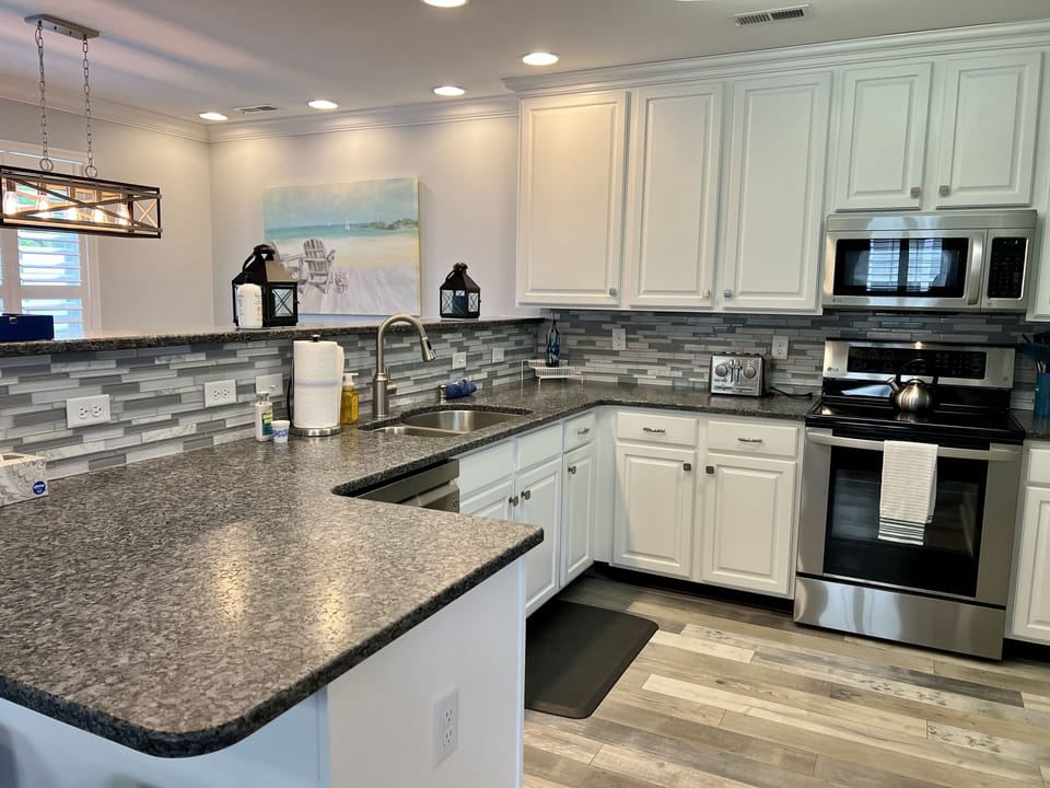 Spacious kitchen with upgraded countertops, backsplash, and appliances. 