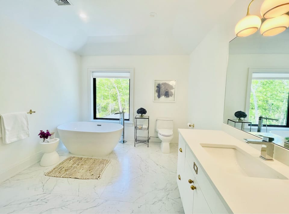 Primary bedroom-ensuite bathroom w/ his and her vanities.Luxe soak tub with view