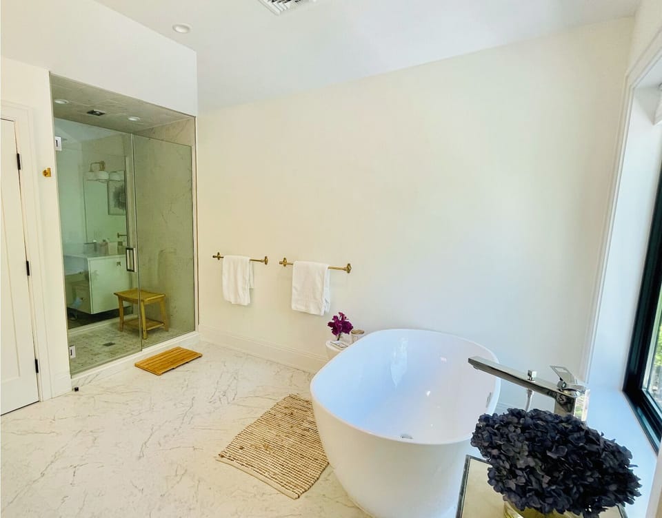 Primary bedroom-ensuite bathroom w/ his and her vanities.Luxe soak tub with view