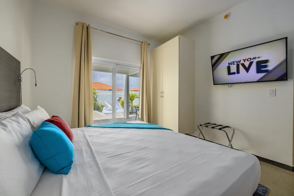 A king-size bedroom that comfortably sleeps 2 people. A television and large sliding door provide access to the outdoor dining and living room space.