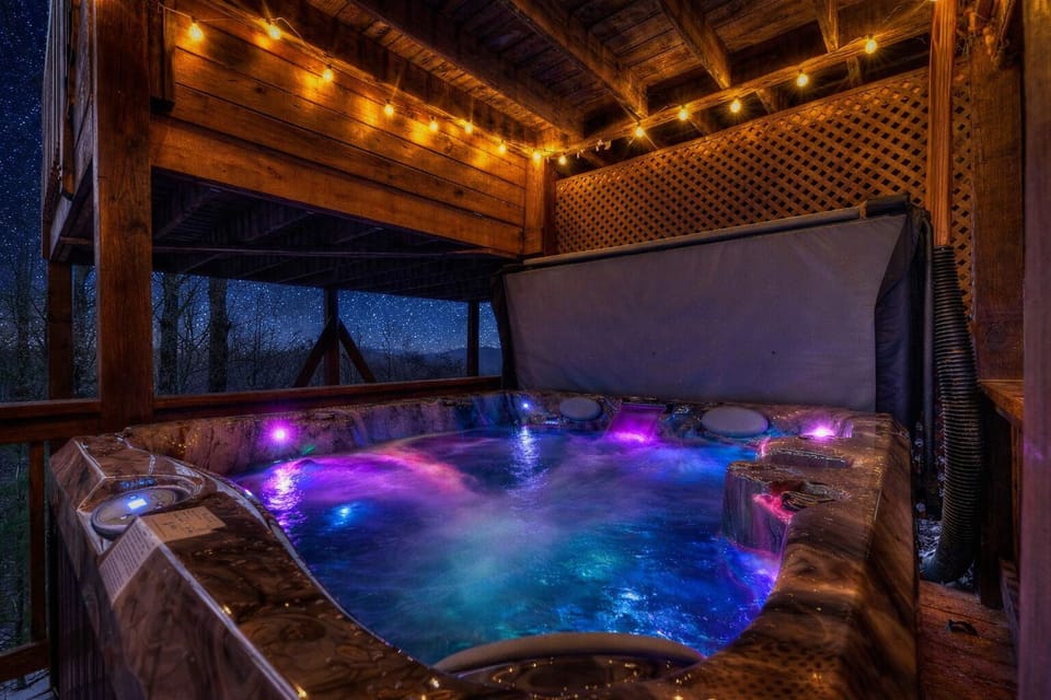 Unwind under the stars in your private hot tub, surrounded by warm string lights, bubbling water, and peaceful mountain cabin vibes.