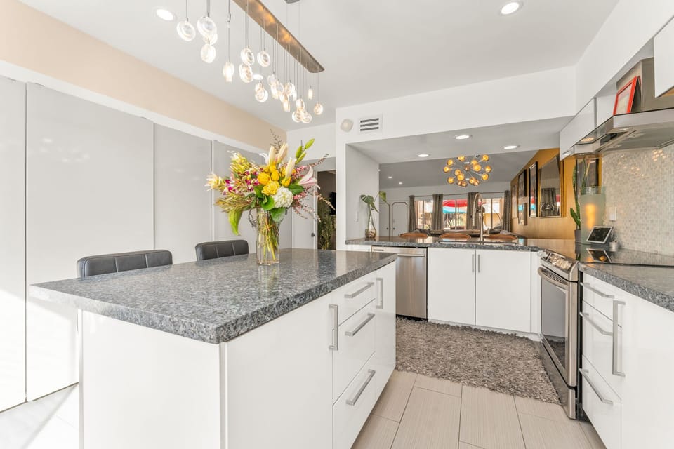 Modern kitchen featuring leathered granite counters and kitchen island for two.