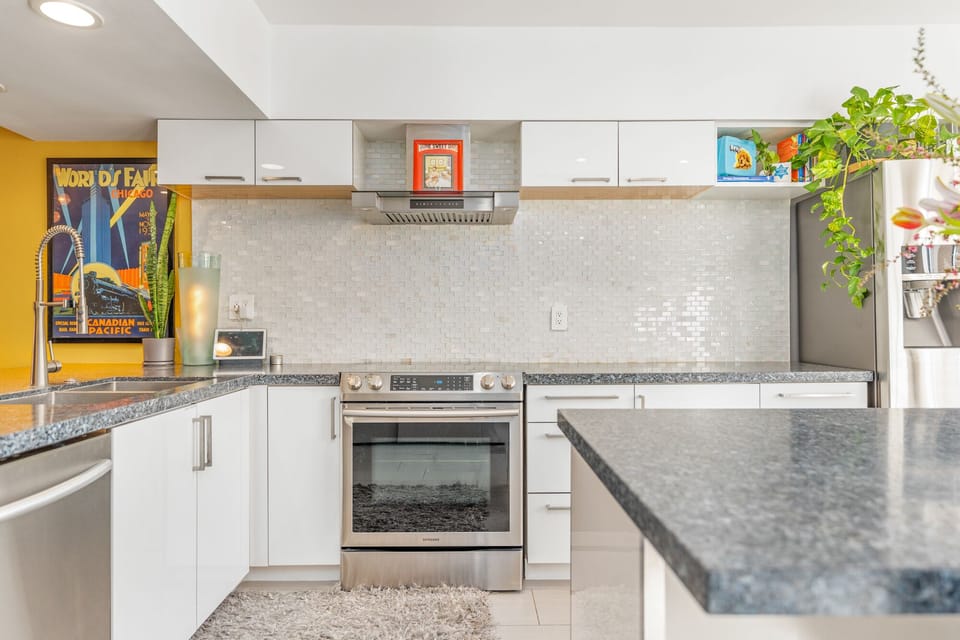 Kitchen features electric cooktop, fridge with ice maker, and a dishwasher. 