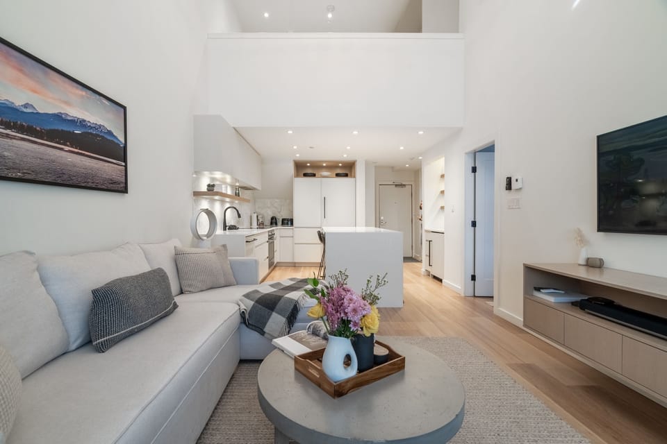 The Spacious living room flows into an open-plan kitchen w/ cathedral ceilings.