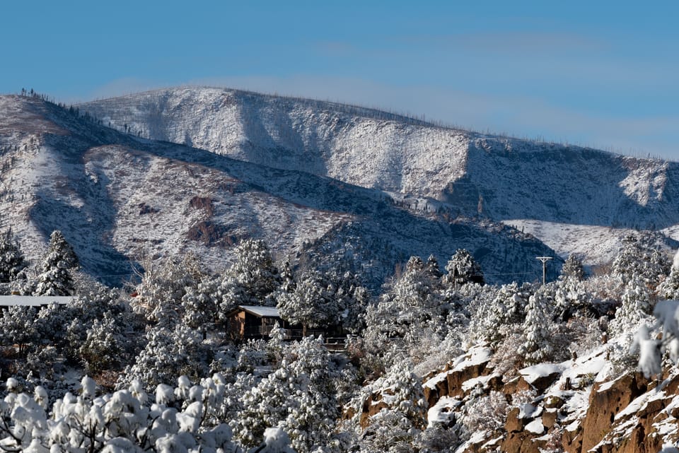 Casa Bear sitting above the canyon, Jemez Mountains in distance.